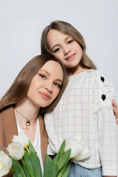Frau umarmt lächelnde Tochter in der Nähe von Tulpen — Stockfoto