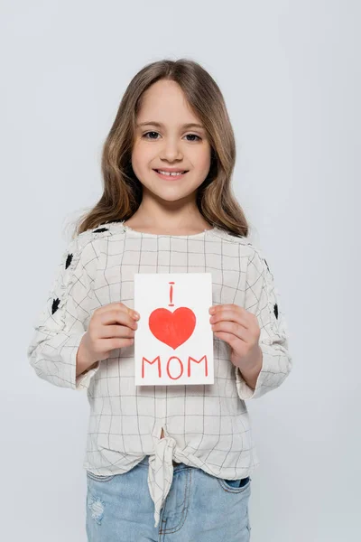 Vorderseite des fröhlichen Mädchens mit Muttertag-Grußkarte isoliert auf grau — Stockfoto