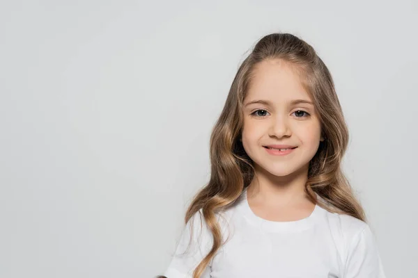 Porträt eines fröhlichen Mädchens mit langen Haaren, das isoliert auf grau in die Kamera blickt — Stockfoto