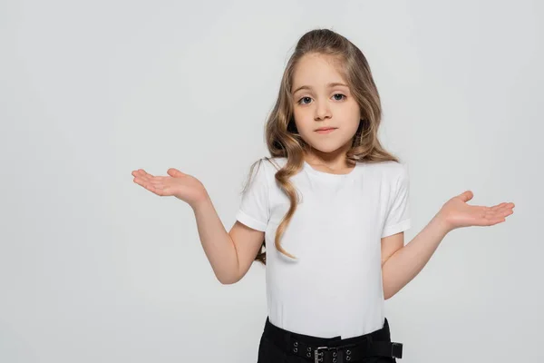 Confused girl showing shrug gesture while looking at camera isolated on grey — Stock Photo