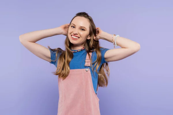 Portrait of happy woman in overall dress isolated on purple — Stock Photo