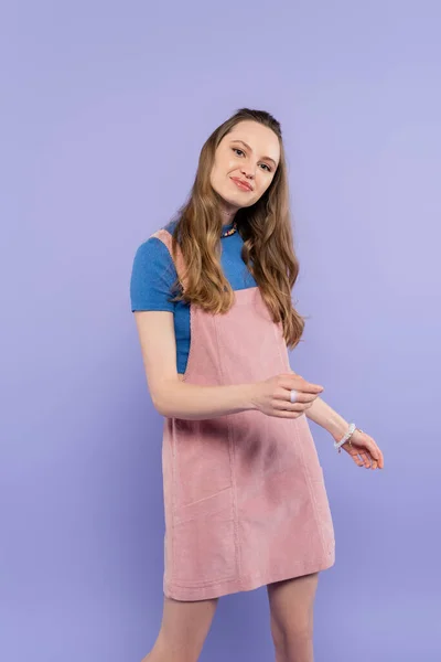 Retrato de mujer sonriente en vestido general aislado en púrpura - foto de stock