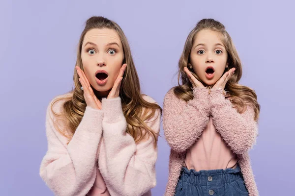 Shocked mother and daughter looking at camera isolated on purple — Stock Photo