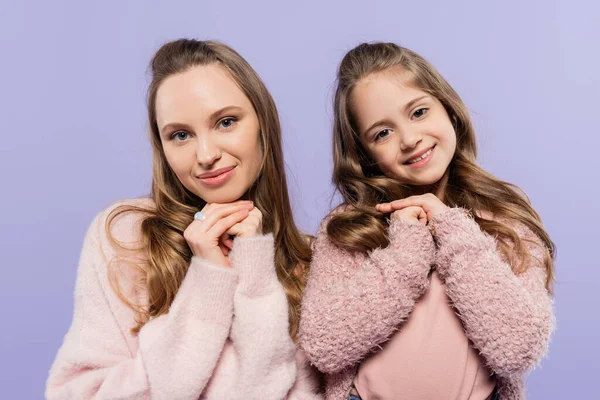 Pleased mother and daughter looking at camera isolated on purple — Stock Photo