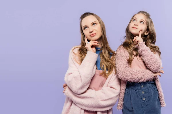 Стомлена мати і дочка, дивлячись ізольовано на фіолетовому — стокове фото