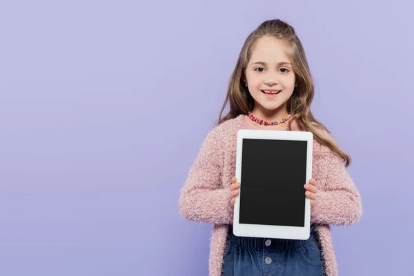 Happy girl holding digital tablet with blank screen isolated on purple — Stock Photo