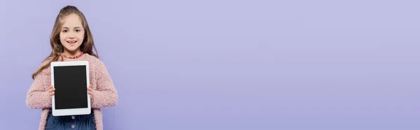 Happy girl holding digital tablet with blank screen isolated on purple, banner — Stock Photo
