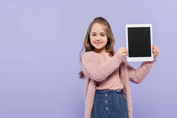 Alegre chica sosteniendo tableta digital con pantalla en blanco aislado en púrpura - foto de stock