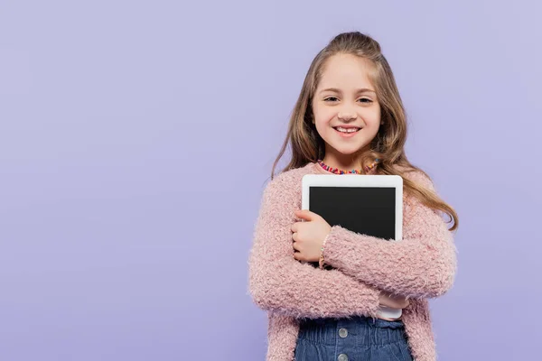 Freudiges Mädchen umarmt digitales Tablet mit leerem Bildschirm isoliert auf lila — Stockfoto