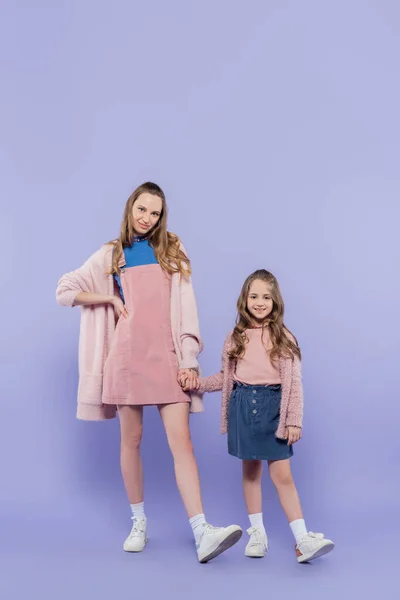 Full length of happy kid and mother holding hands on purple — Stock Photo