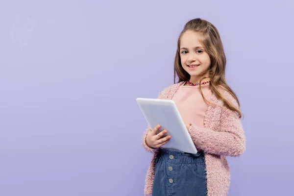 Радостный ребенок с помощью цифровой таблетки изолированы на фиолетовый — стоковое фото