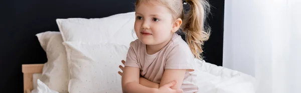 Girl with ponytail sitting with crossed arms in bedroom, banner — Stock Photo