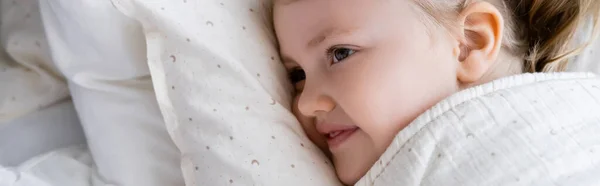 Vista ad alto angolo di ragazza positiva sdraiata a letto a casa, banner — Foto stock