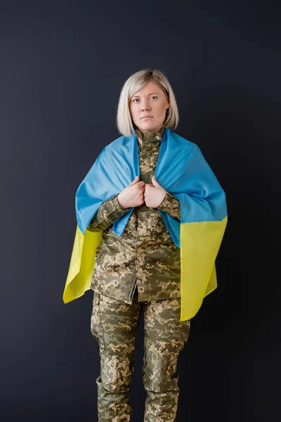 Vista frontale di donna militare con bandiera ucraina su spalle isolate su nero — Foto stock