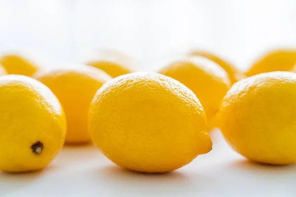 Vista de cerca de limones frescos con luz sobre fondo blanco - foto de stock