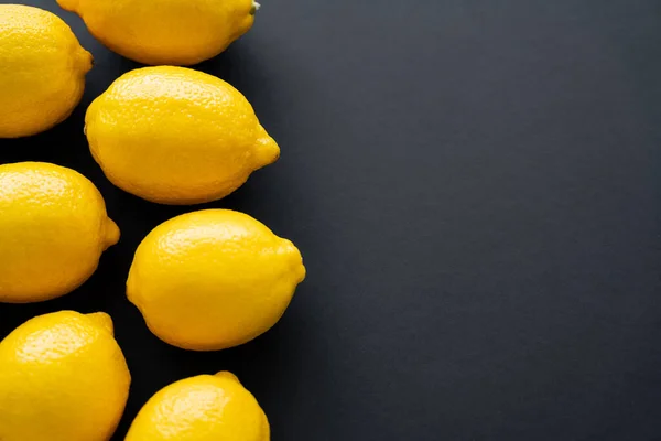 Top view of bright lemons on black background with copy space — Fotografia de Stock