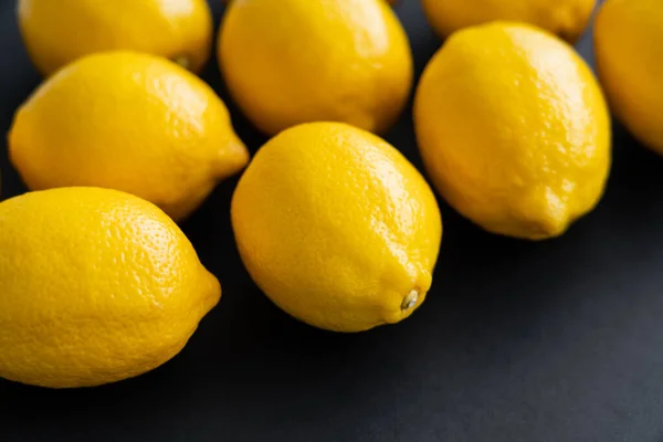 Close up view of fresh lemons on black background — Photo de stock