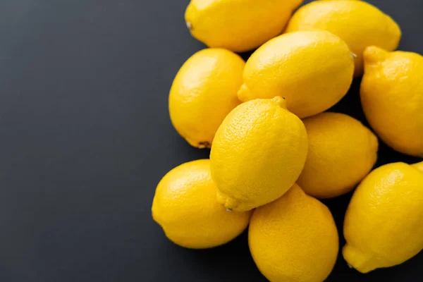 Top view of heap of lemons on black background — стоковое фото
