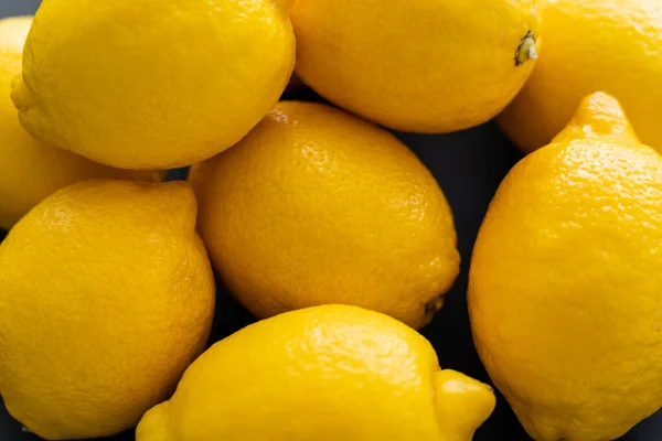 Close up view of yellow lemons on black background — Photo de stock