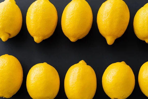 Puesta plana con limones orgánicos sobre fondo negro - foto de stock