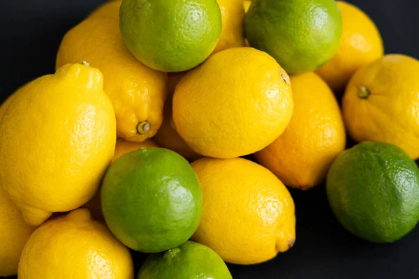 High angle view of organic lemons and limes on black background — Fotografia de Stock