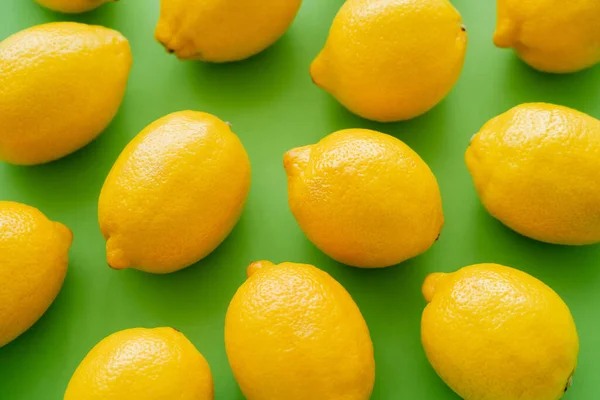 Vista dall'alto di limoni freschi e luminosi su sfondo verde — Foto stock