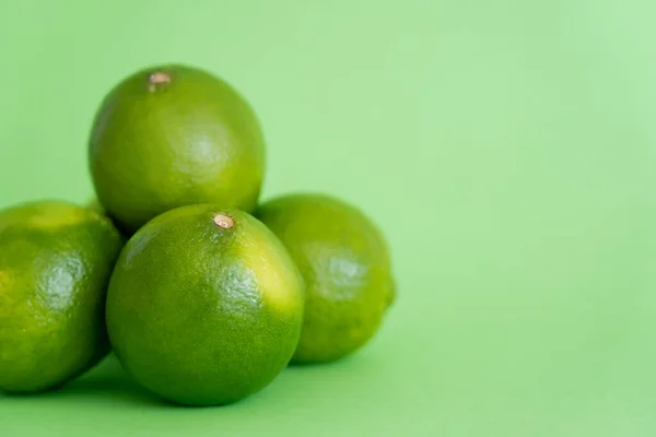 Close up view of ripe limes on green background — Stock Photo