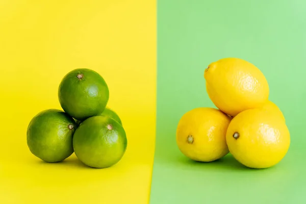 Bight limes and lemons on green and yellow background - foto de stock