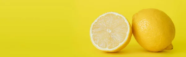 Close up view of juicy half and whole lemon on yellow background, banner - foto de stock