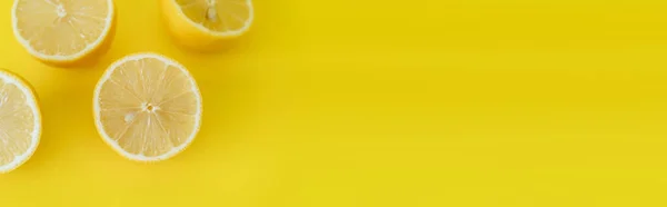 Top view of juicy halves of lemons on yellow background with copy space, banner - foto de stock