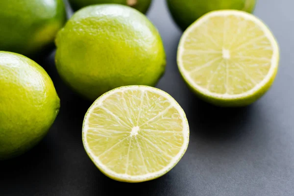 Close up view of fresh half of lime on black background - foto de stock