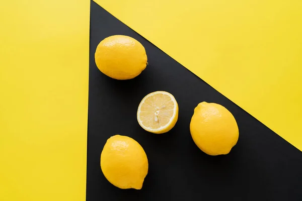 Vista superior de limones sobre fondo negro y amarillo - foto de stock
