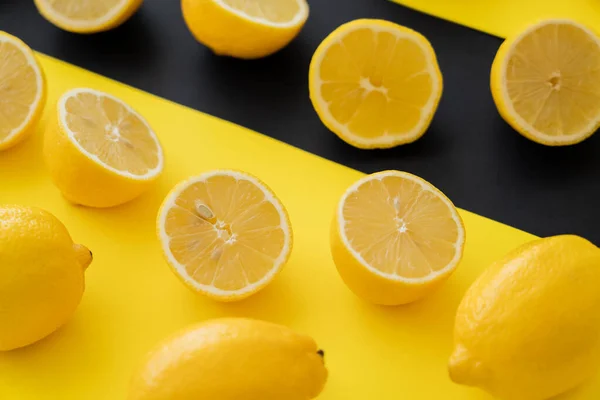 Close up view of organic lemons on black and yellow background — стоковое фото