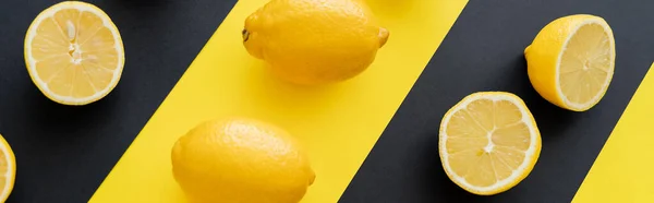 Colocación plana con limones maduros sobre fondo negro y amarillo, pancarta - foto de stock