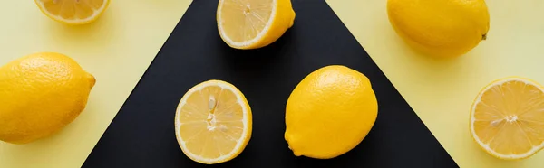 Flat lay of ripe lemons on beige and black background, banner — Fotografia de Stock