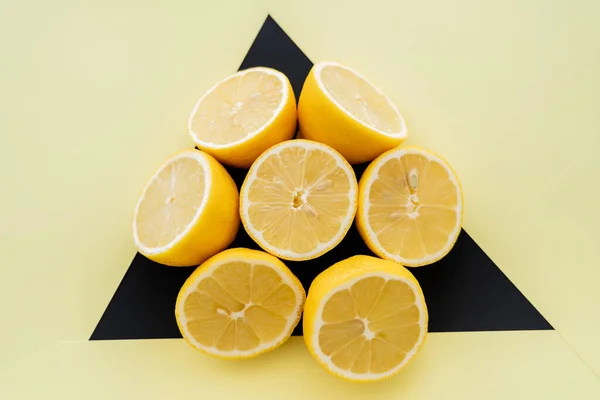 Top view of round from cut lemons on beige and black background — Fotografia de Stock