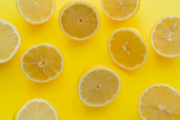 Top view of halves of fresh lemons on yellow surface — Fotografia de Stock