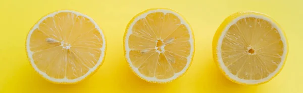 Top view of halves of lemons on yellow background, banner — Photo de stock