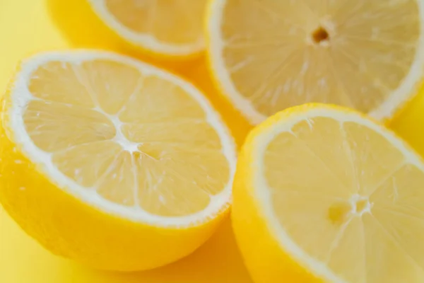 Vista de cerca de limones cortados frescos en la superficie amarilla - foto de stock