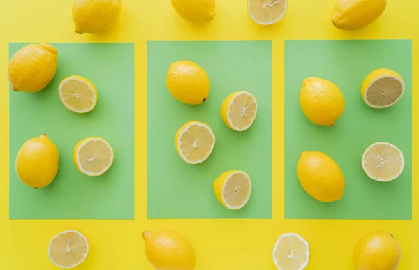 Vista superior de limones brillantes frescos sobre fondo verde y amarillo - foto de stock