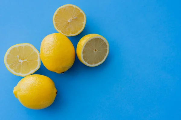 Vista superior de limones jugosos sobre fondo azul - foto de stock