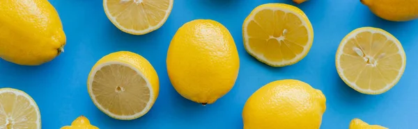 Top view of organic yellow lemons on blue background, banner — Foto stock