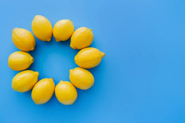 Top view of frame from bright lemons on blue background — Fotografia de Stock