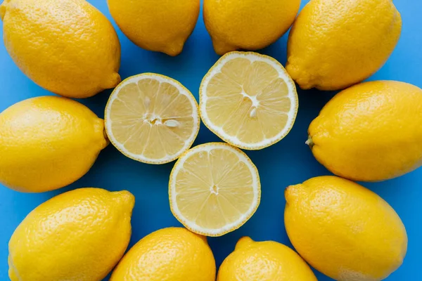 Вид зверху на розрізані лимони в центрі круглих на синьому фоні — стокове фото