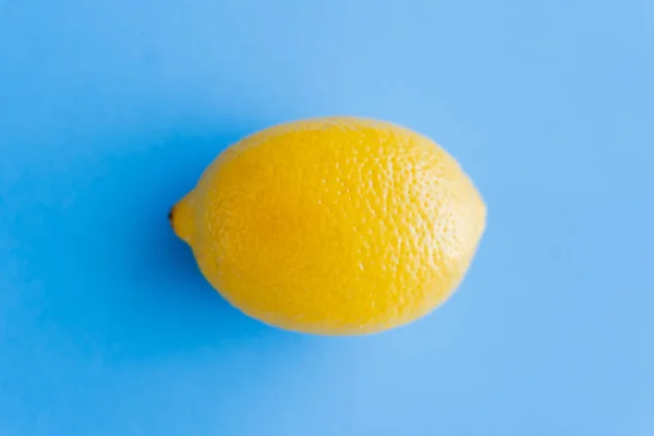 Top view of bright yellow lemon on blue background — Fotografia de Stock