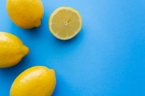 Top view of bright lemons on blue background with copy space — Stockfoto