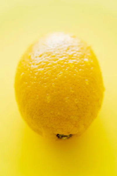Close up view of wet lemon on yellow background — Stock Photo