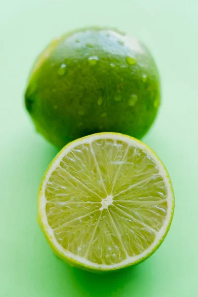 Close up view of juicy cut lime on green background - foto de stock