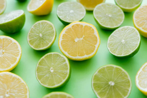 Close up view of cut and juicy citrus fruits on green background — стоковое фото