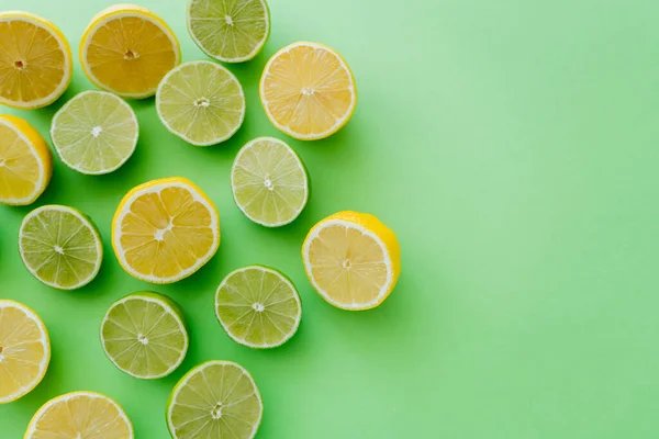 Top view of cut citrus on green background — стоковое фото